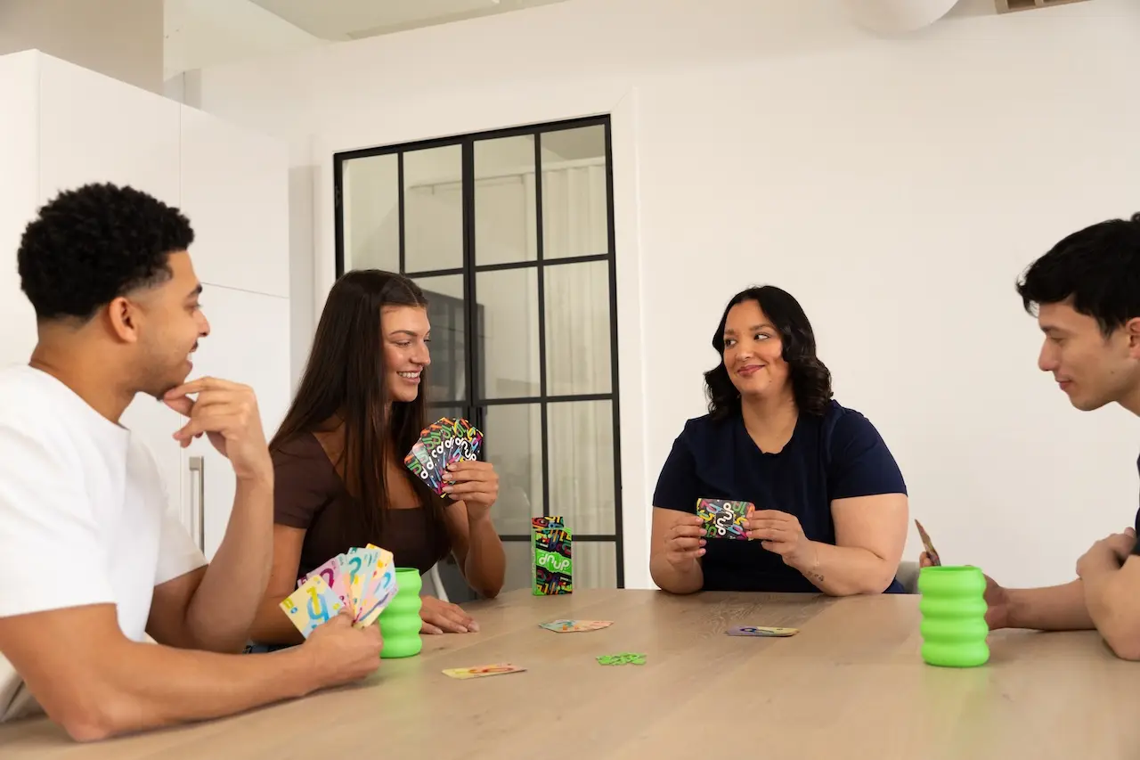Friends playing dnup card game together at a table